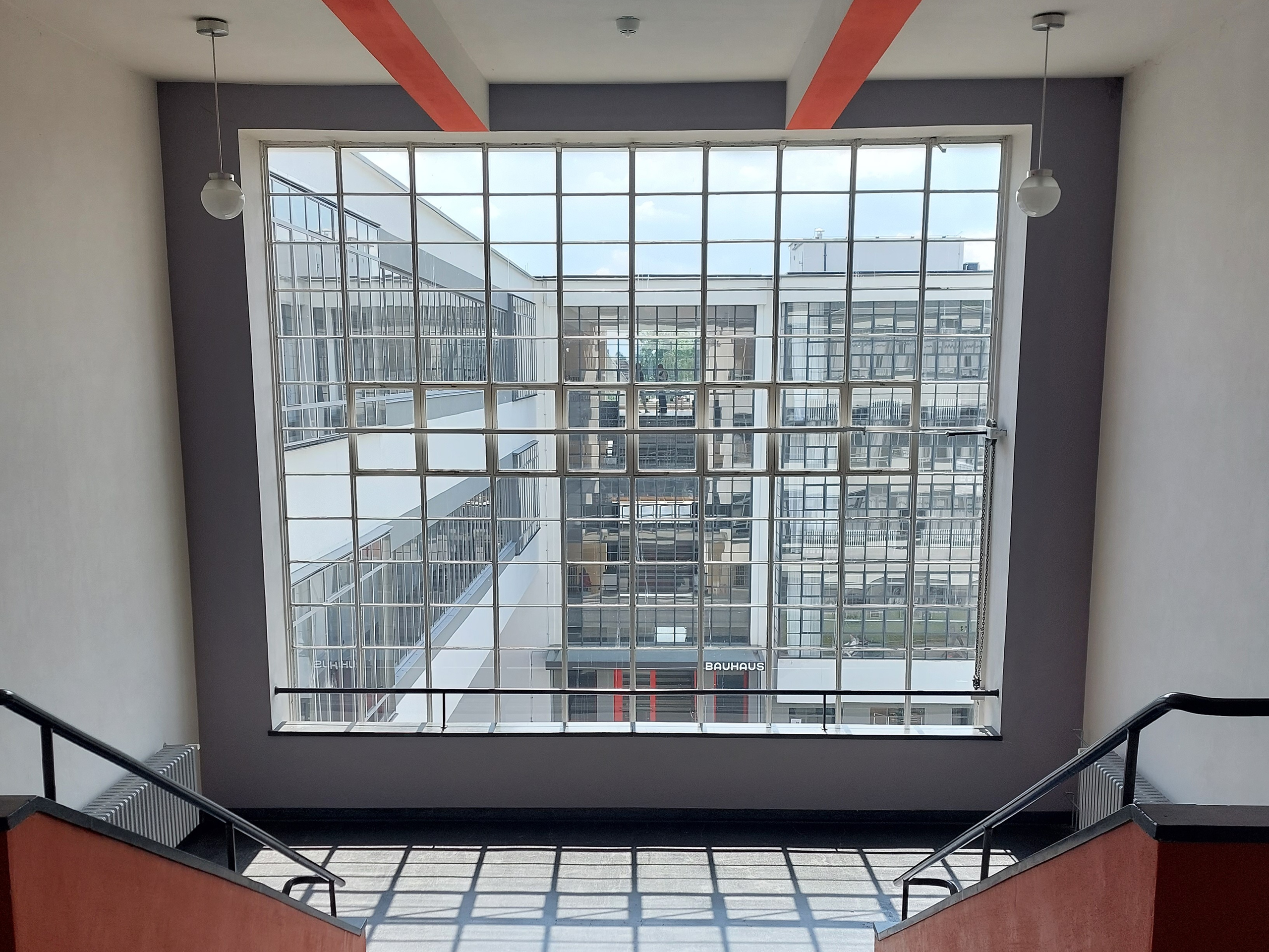 Blick aus einer Fensterfront im Bauhaus-Gebäude in Dessau auf den gegenüber liegenden Haupteingang.